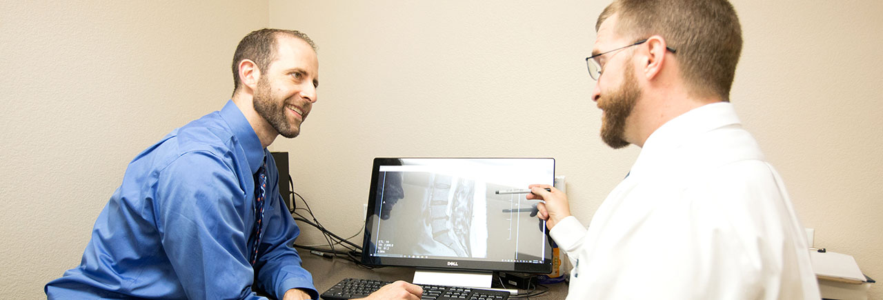 nnc-slide6-optimized NNC doctors examining back x-ray