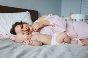 Mom and baby lying on a bed