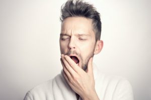 man with TMJ pain opening his mouth in a yawn